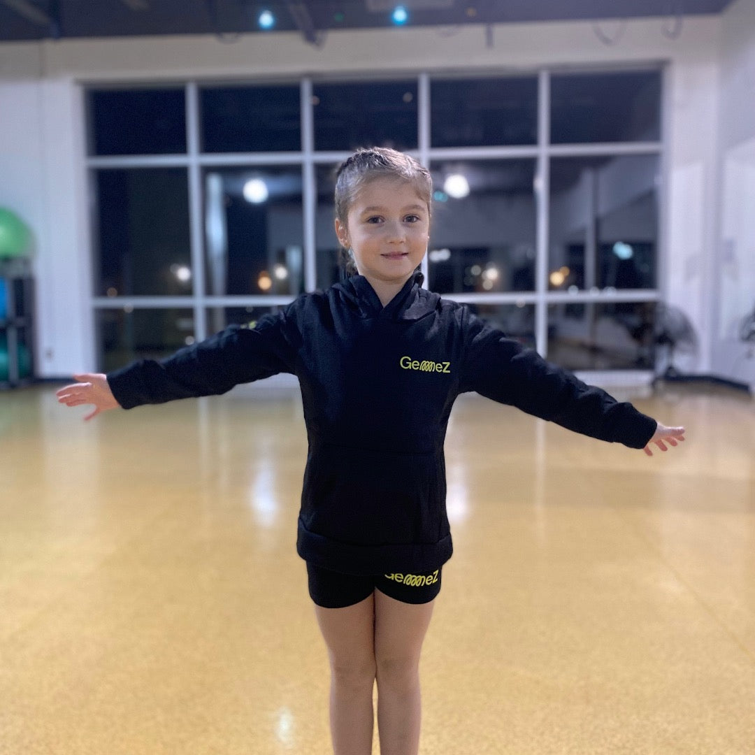Gymnast showcasing the Gemmez brand Black Hoodie with the Gemmez brand shorts
