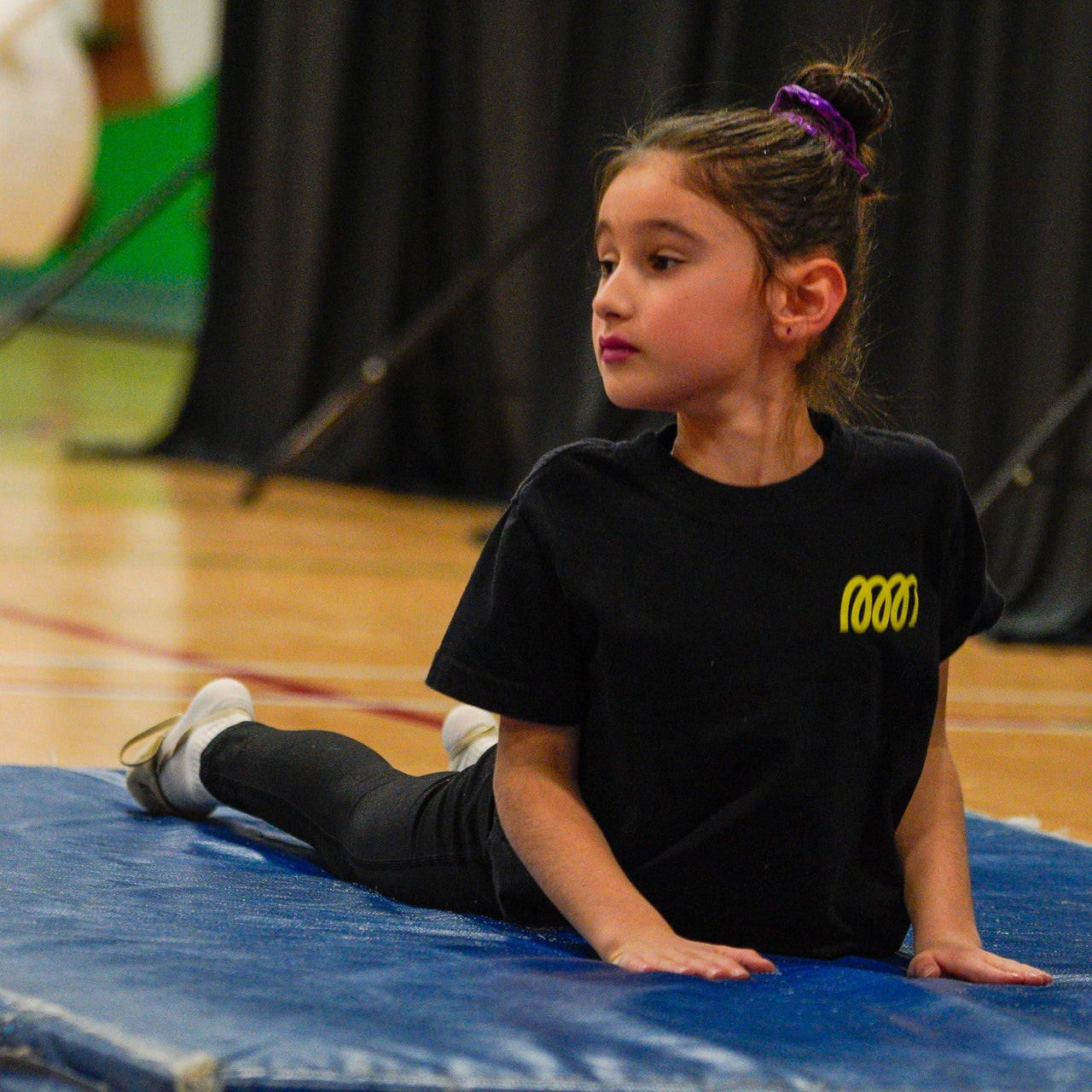 Gymnast in cobra stretch on a blue mat