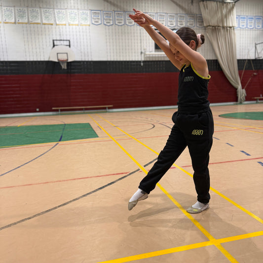 Gymnast wearing Gemmez brand joggers and tank top preparing for cartwheel