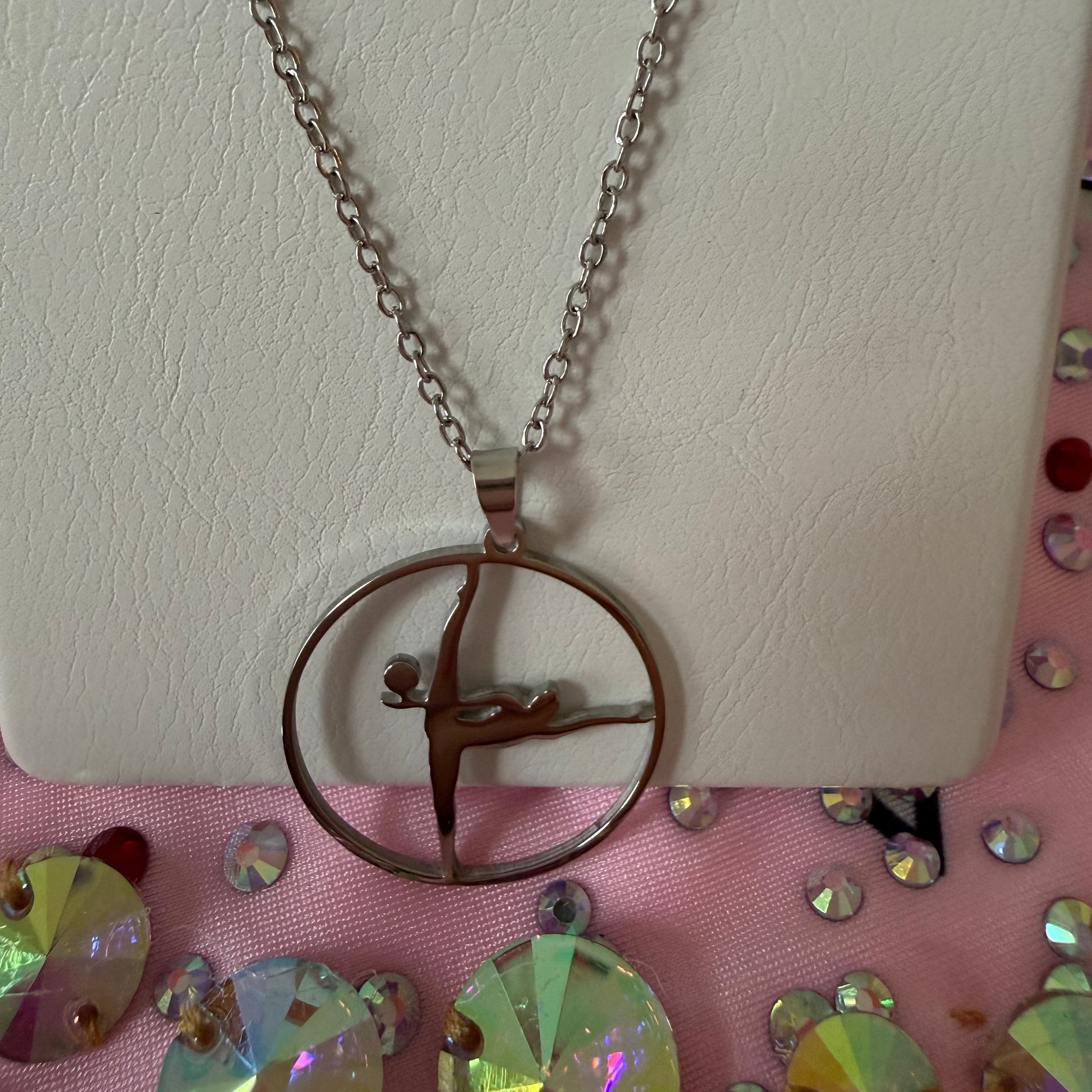 Necklace with a gymnast in a balance position with a ball pendant on a pink leotard with rhinestones