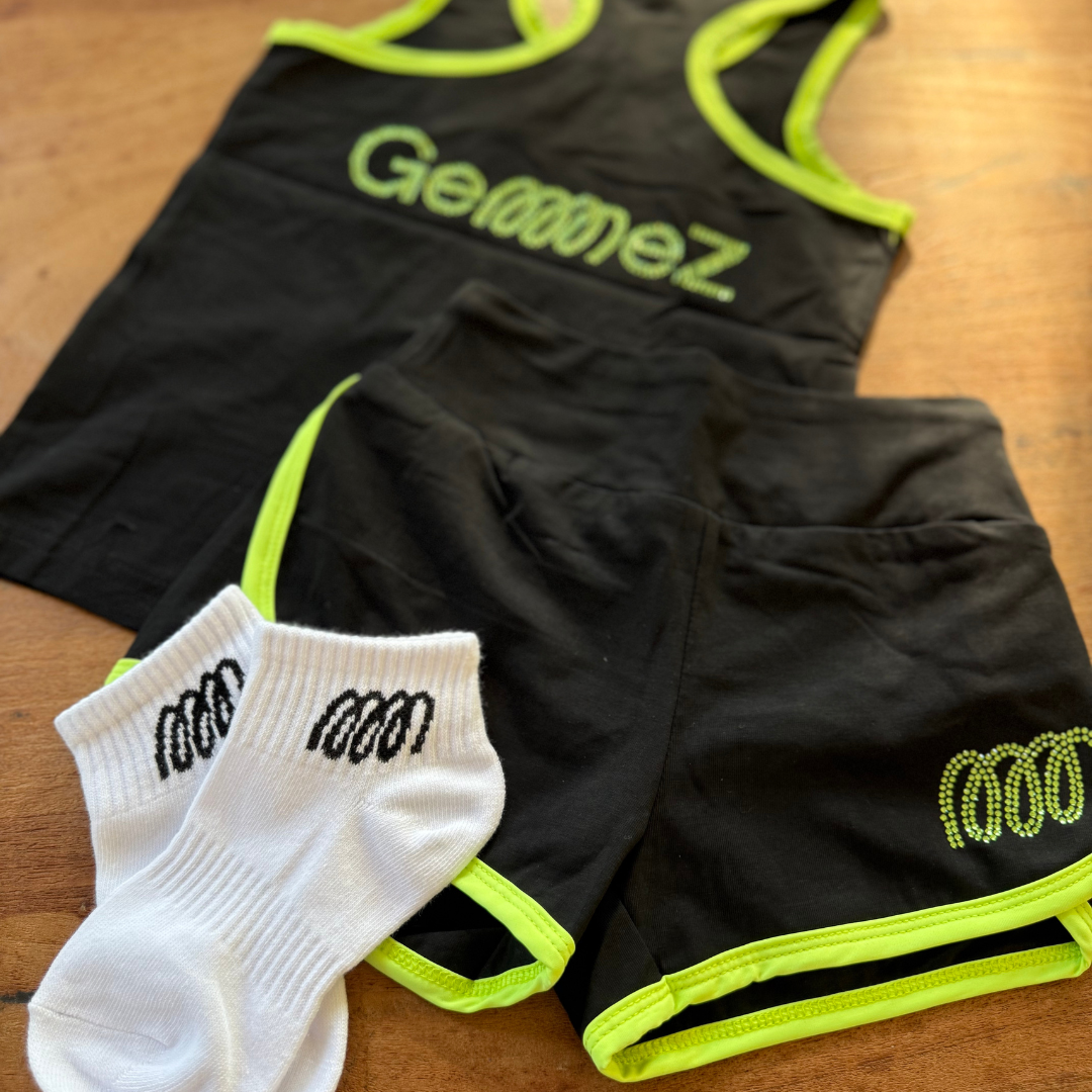 Black athletic outfit with neon green accents and white socks with 'Gemmez' branding on a wooden surface.